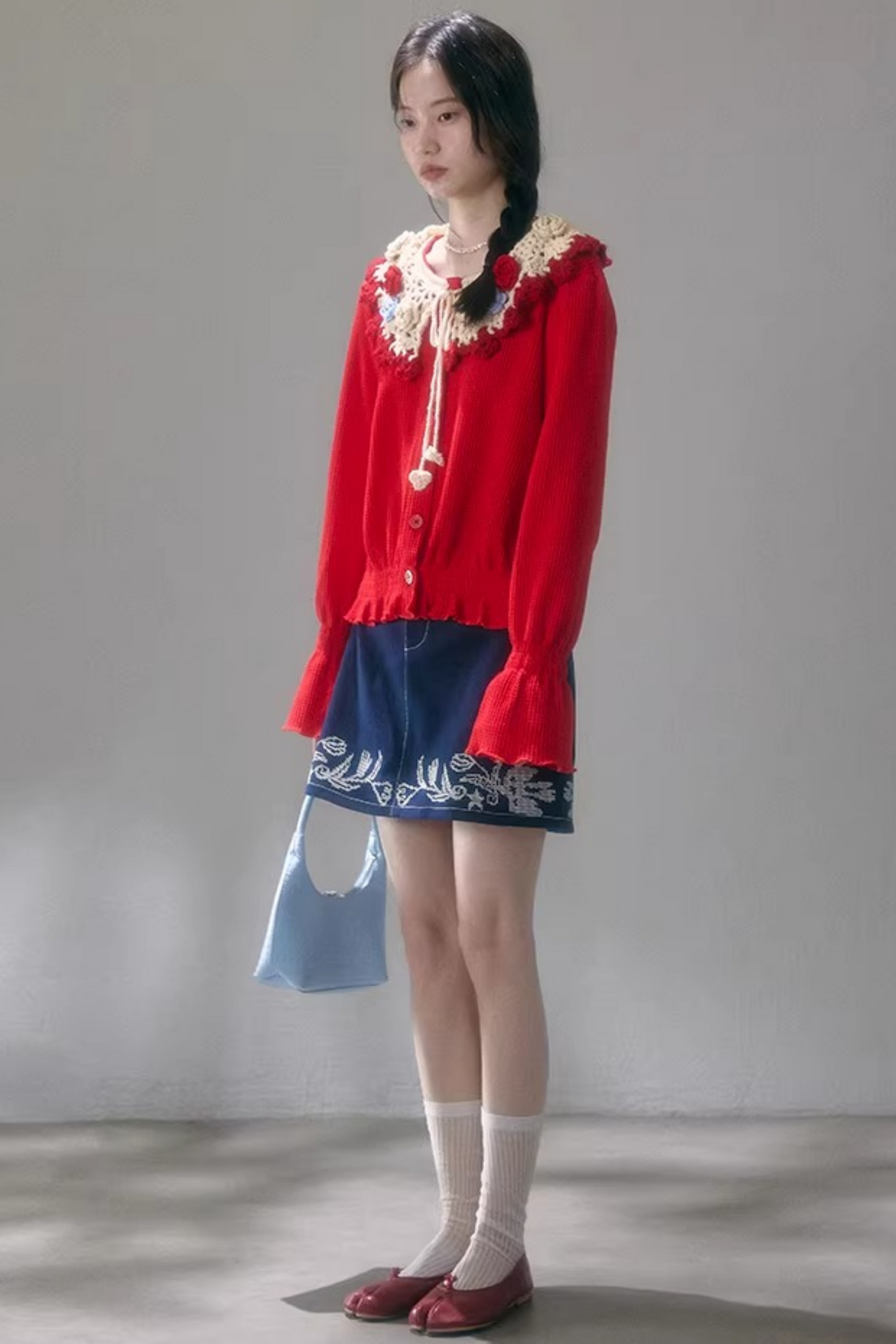 Gehäkelte Strickjacke mit floraler Kamelie
