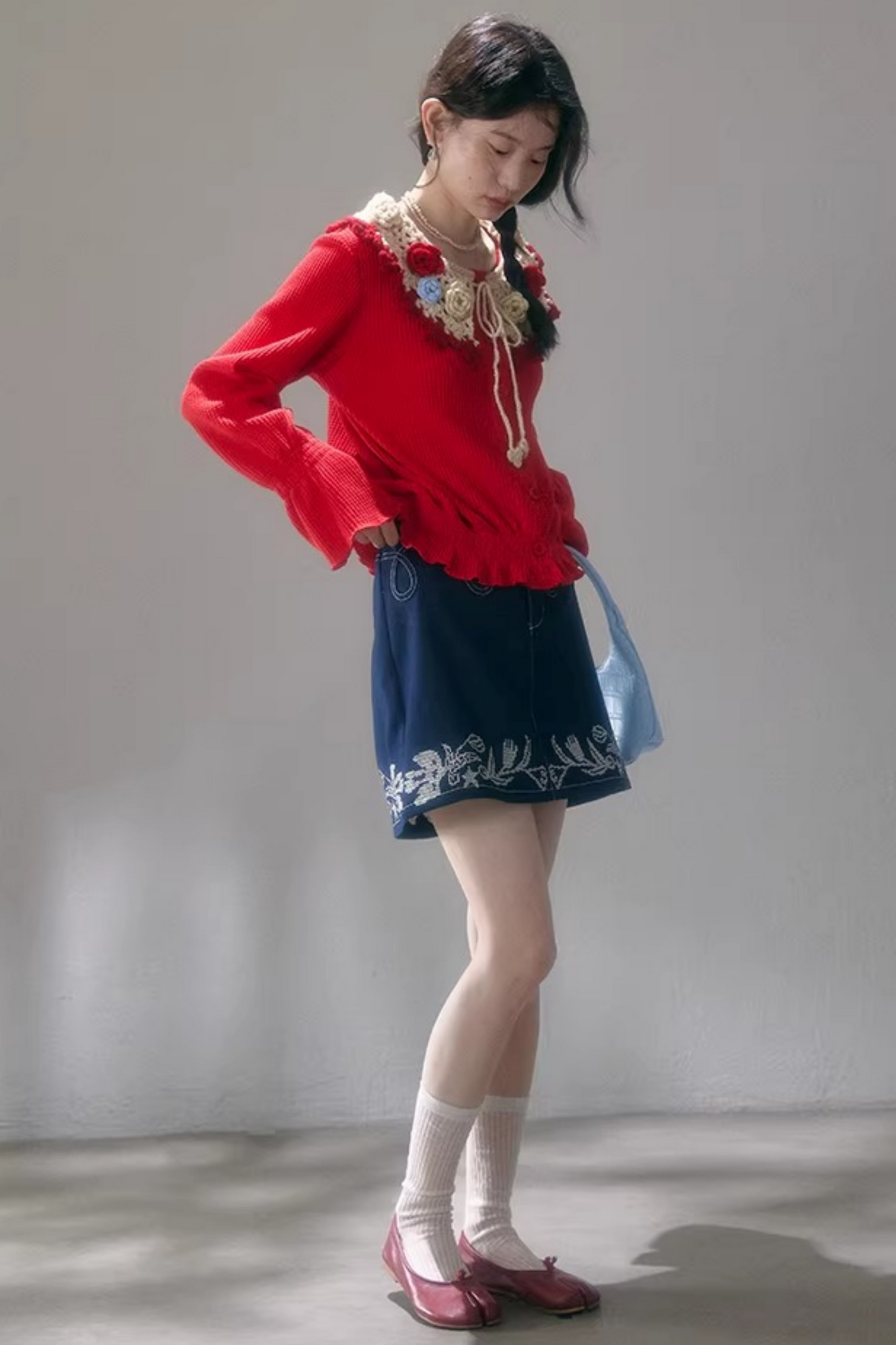 Gehäkelte Strickjacke mit floraler Kamelie