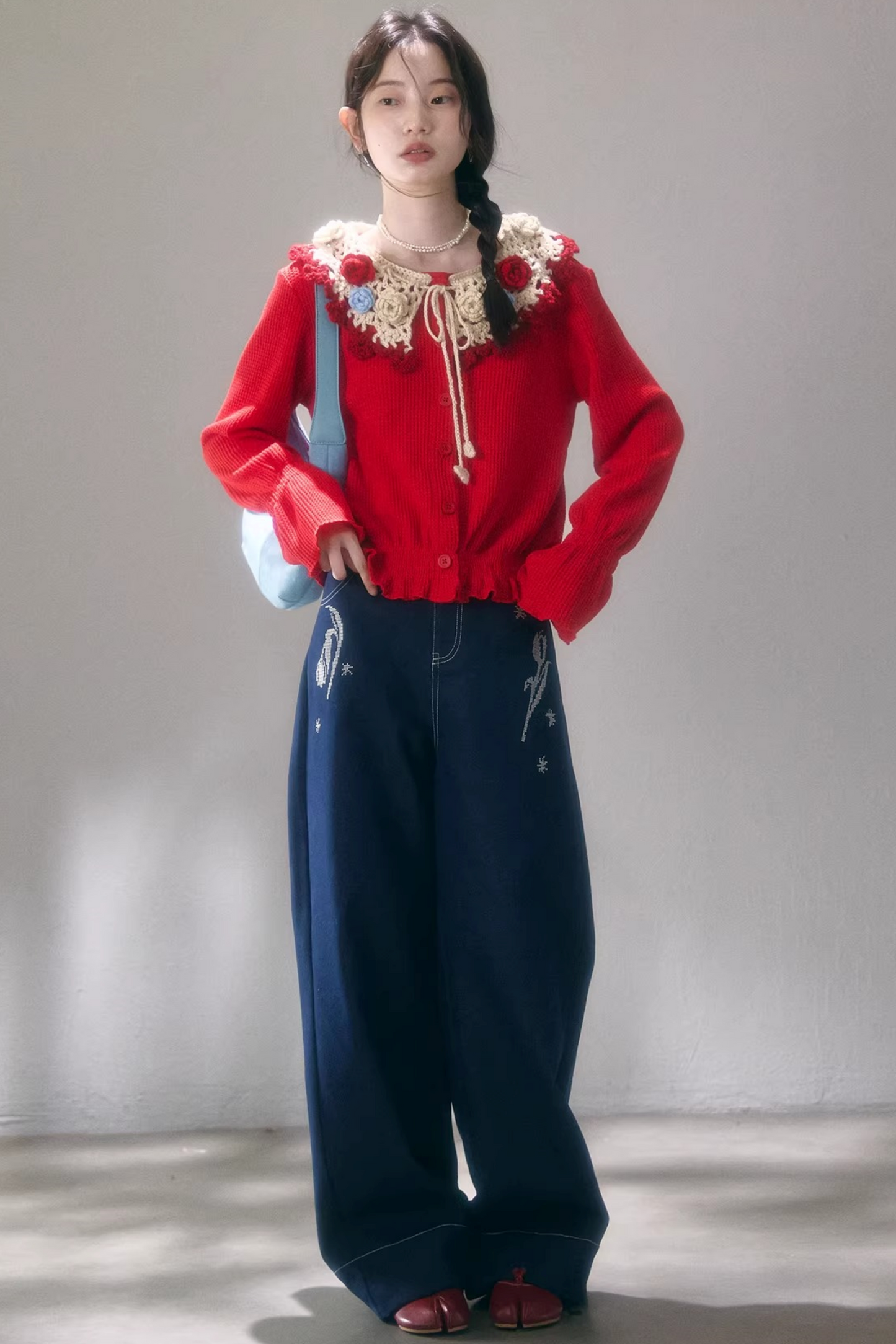 Gehäkelte Strickjacke mit floraler Kamelie