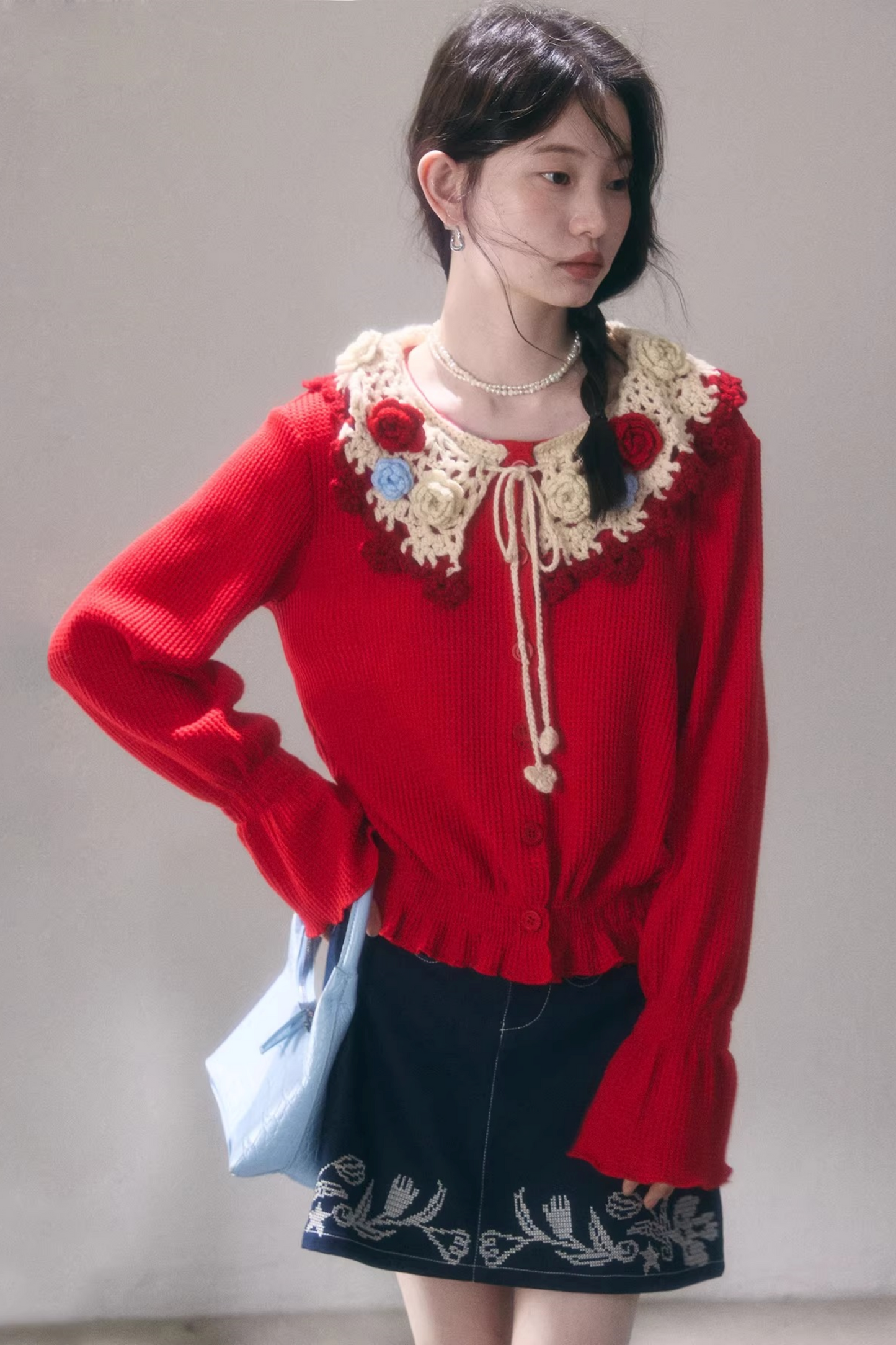 Gehäkelte Strickjacke mit floraler Kamelie