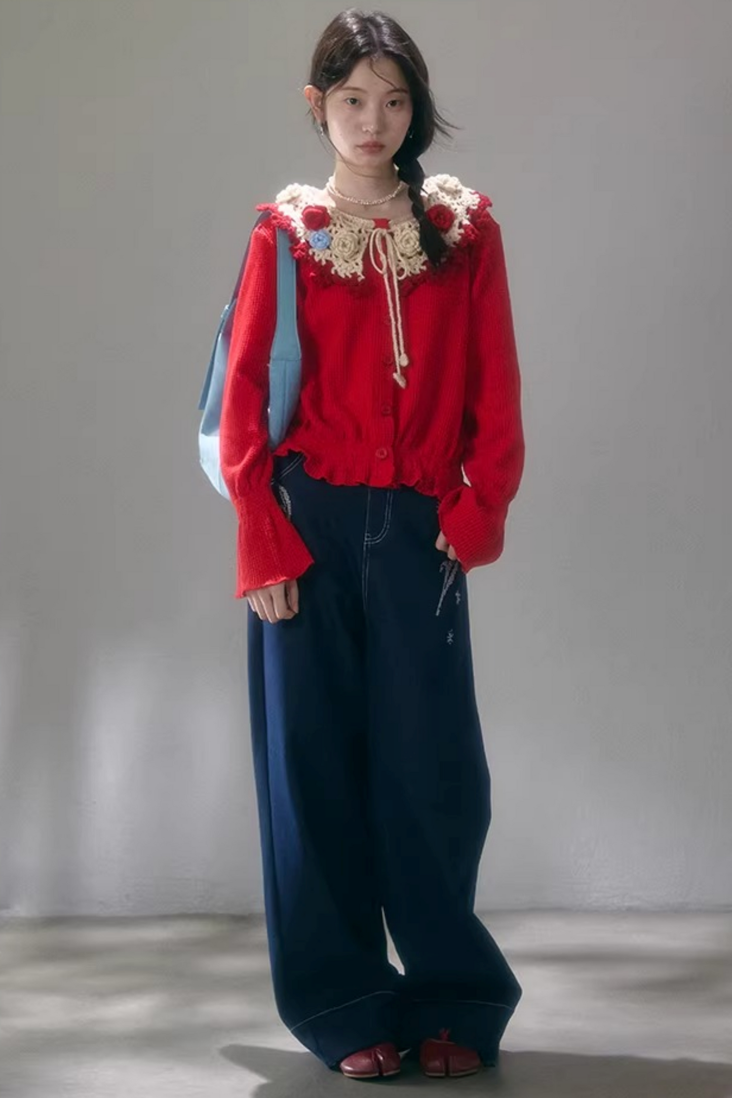 Gehäkelte Strickjacke mit floraler Kamelie