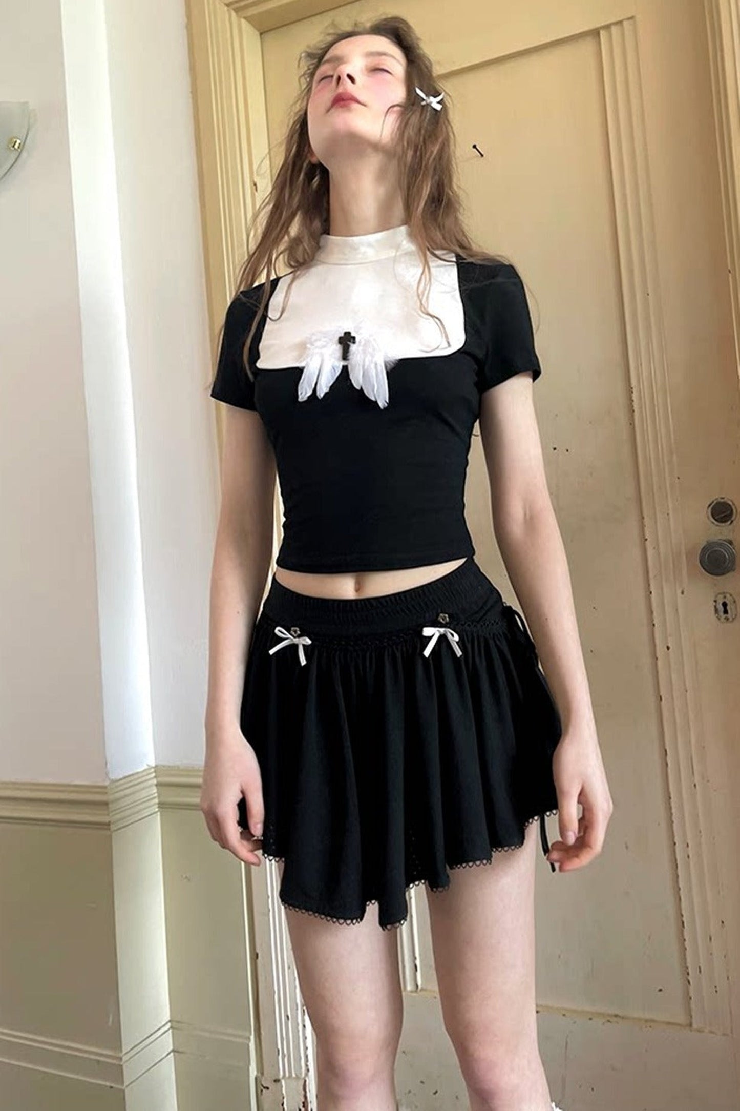 T-shirt bianca e nera a inserti con piuma e croce