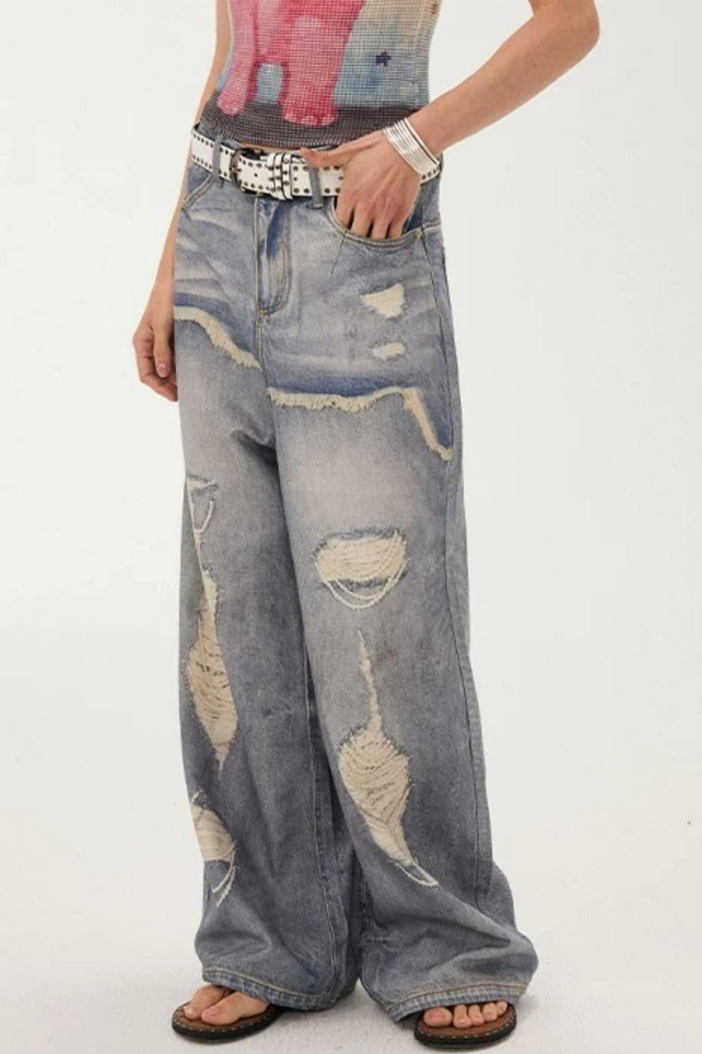 Jeans a gamba larga con stampa effetto strappato e look a strati