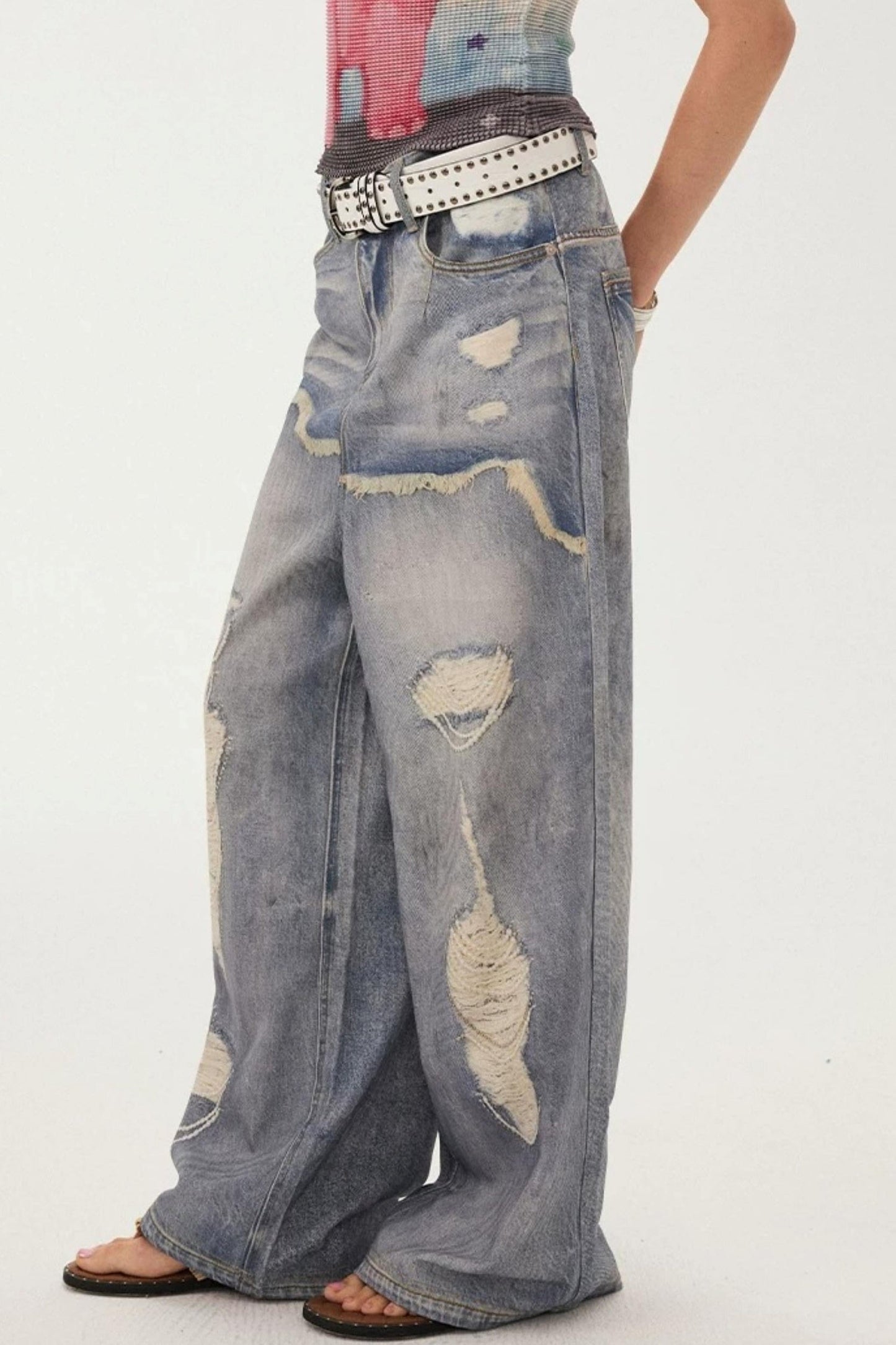 Jeans a gamba larga con stampa effetto strappato e look a strati