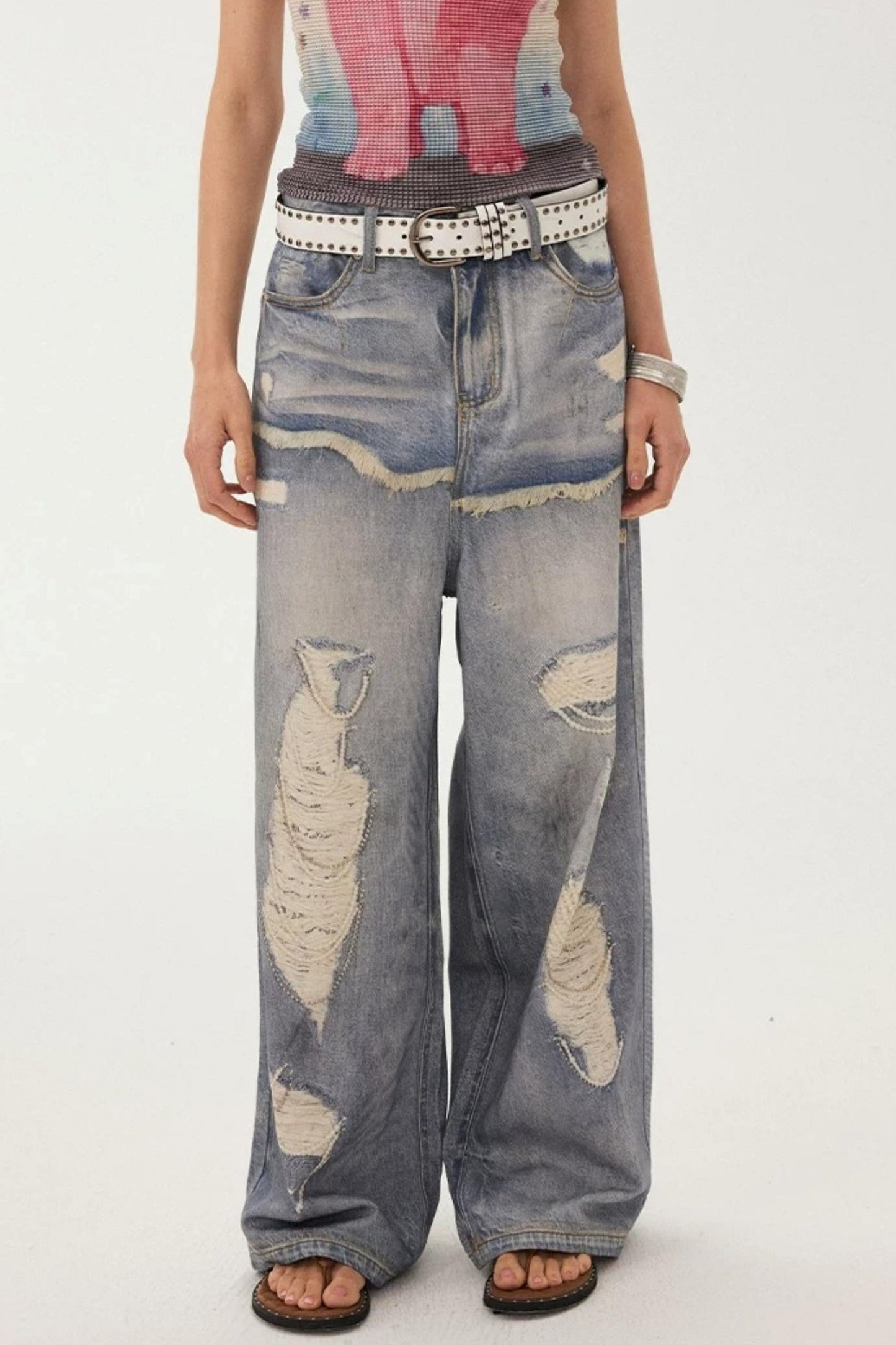 Jeans a gamba larga con stampa effetto strappato e look a strati