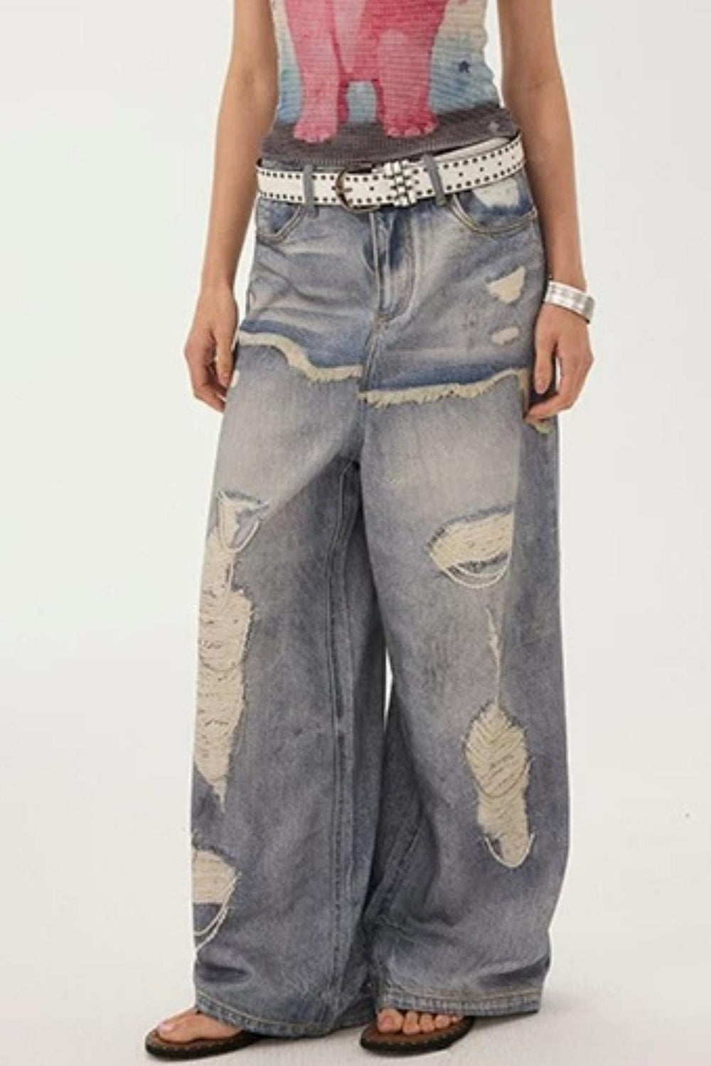 Jeans a gamba larga con stampa effetto strappato e look a strati