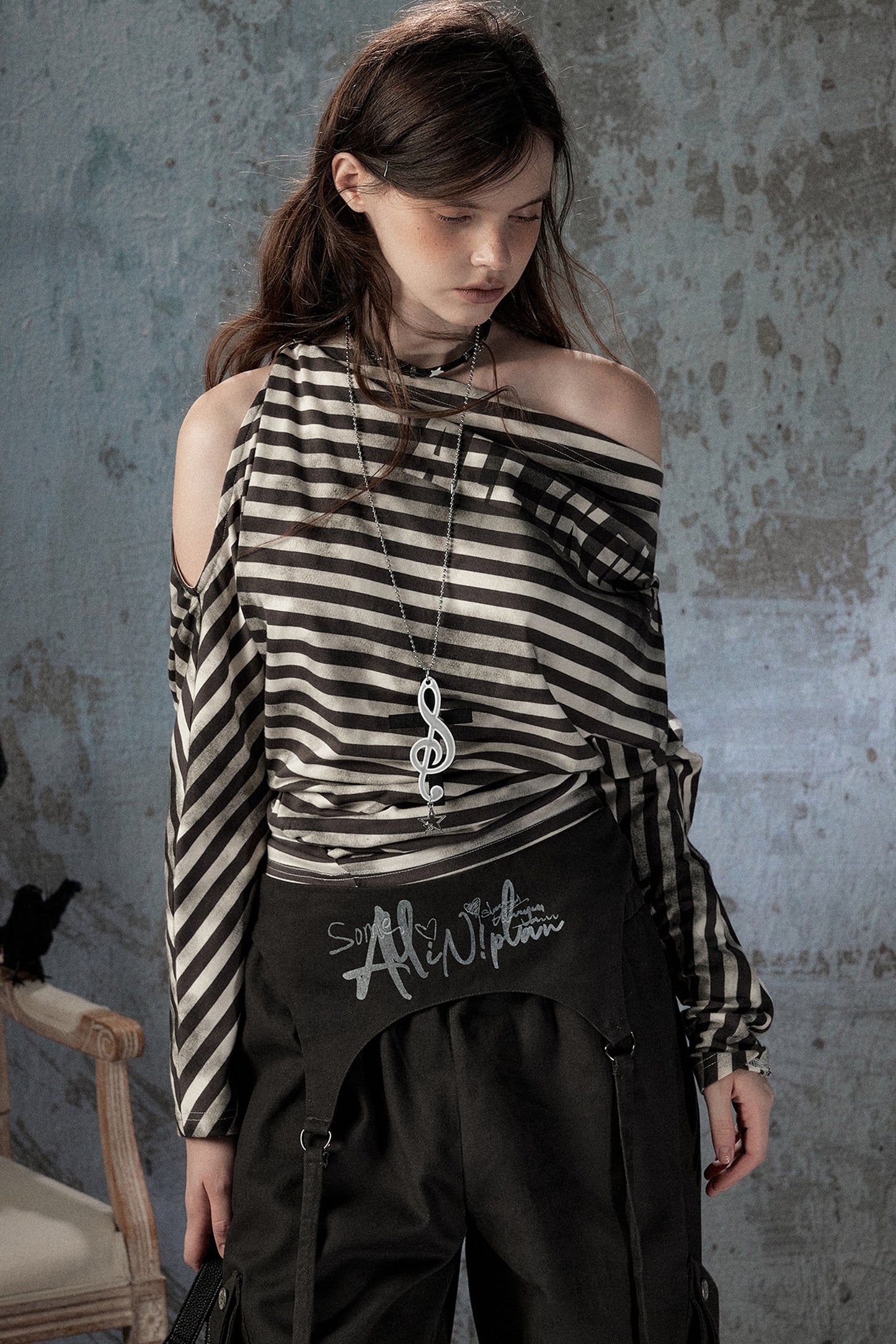 Top asimmetrico a righe con spalle scoperte e maniche lunghe