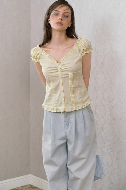 Blusa giallo crema con volant, scollo a V e maniche a sbuffo