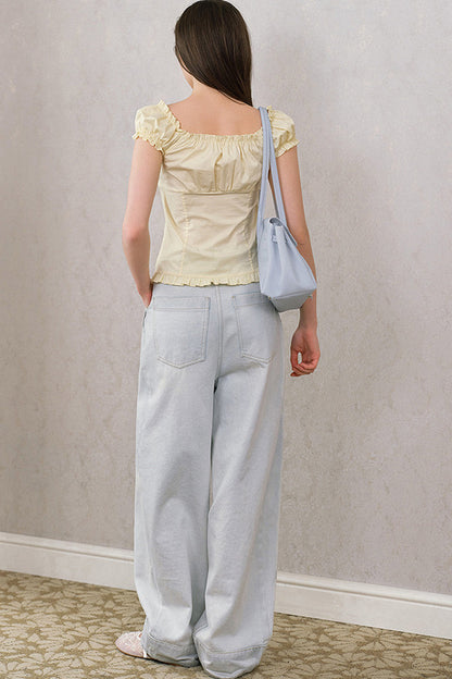 Blusa giallo crema con volant, scollo a V e maniche a sbuffo