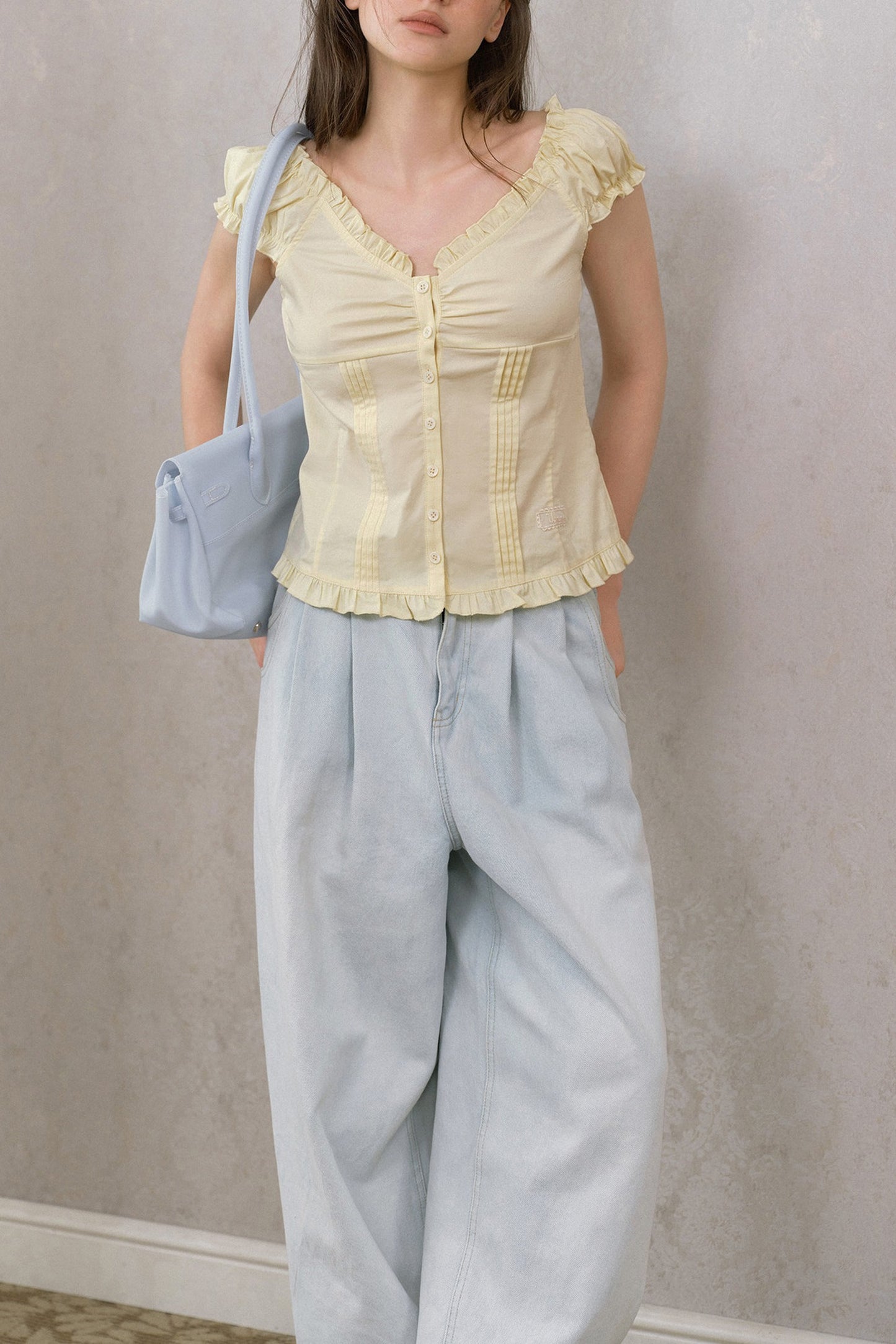 Blusa giallo crema con volant, scollo a V e maniche a sbuffo