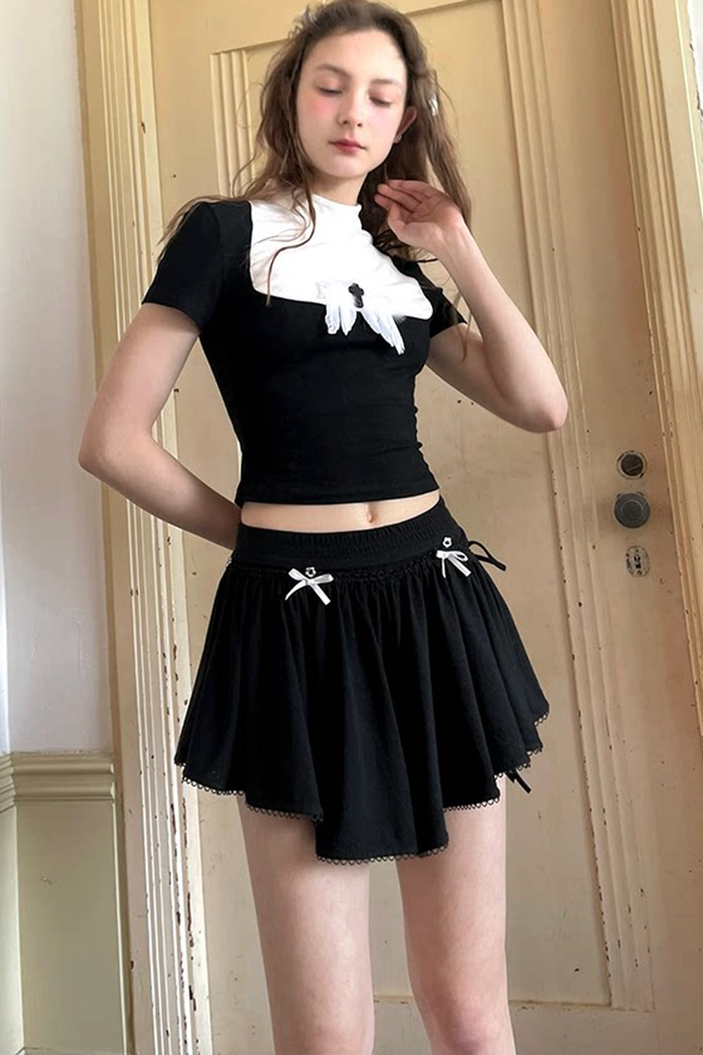 T-shirt bianca e nera a inserti con piuma e croce