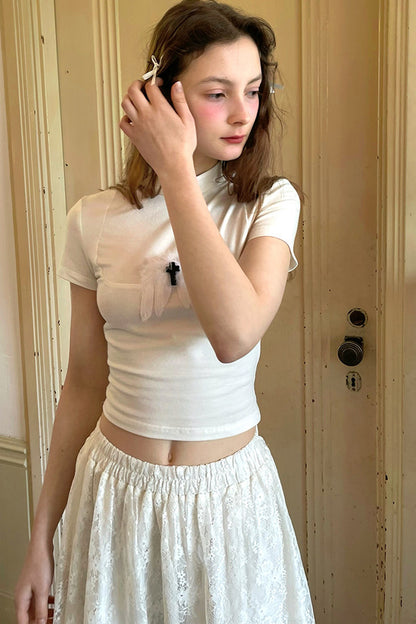 T-shirt bianca e nera a inserti con piuma e croce