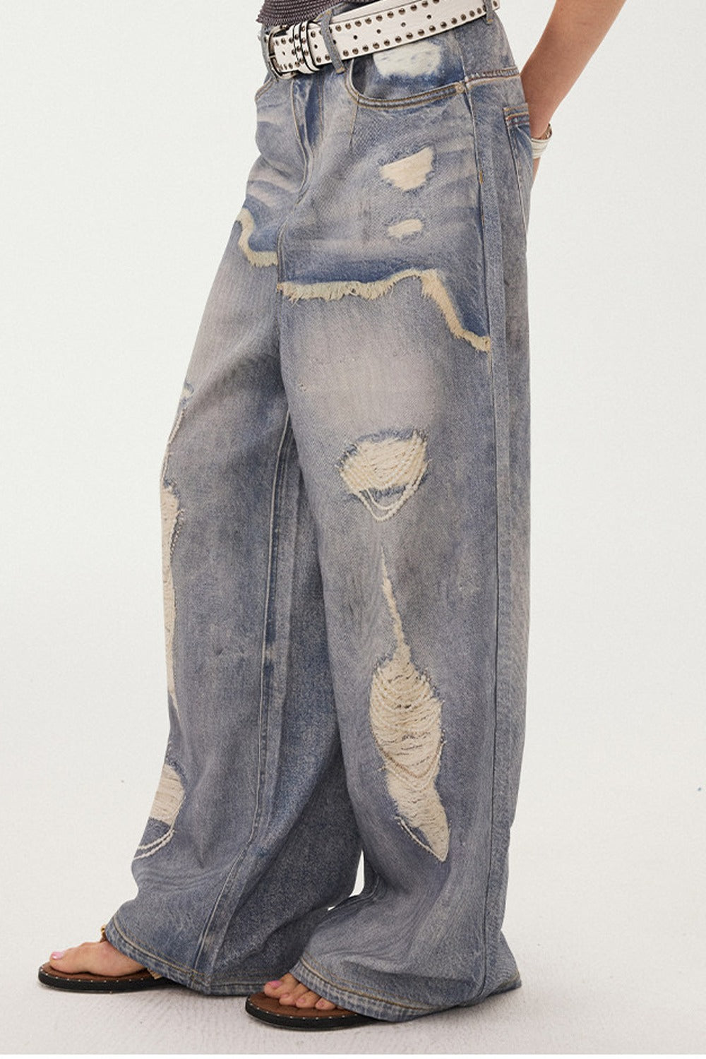 Jeans a gamba larga con stampa effetto strappato e look a strati