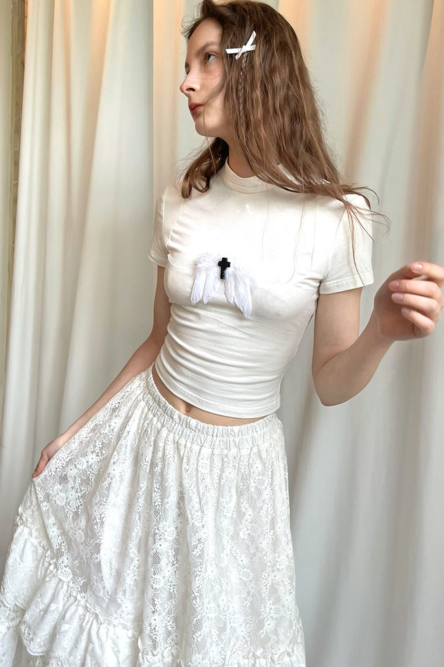 T-shirt bianca e nera a inserti con piuma e croce