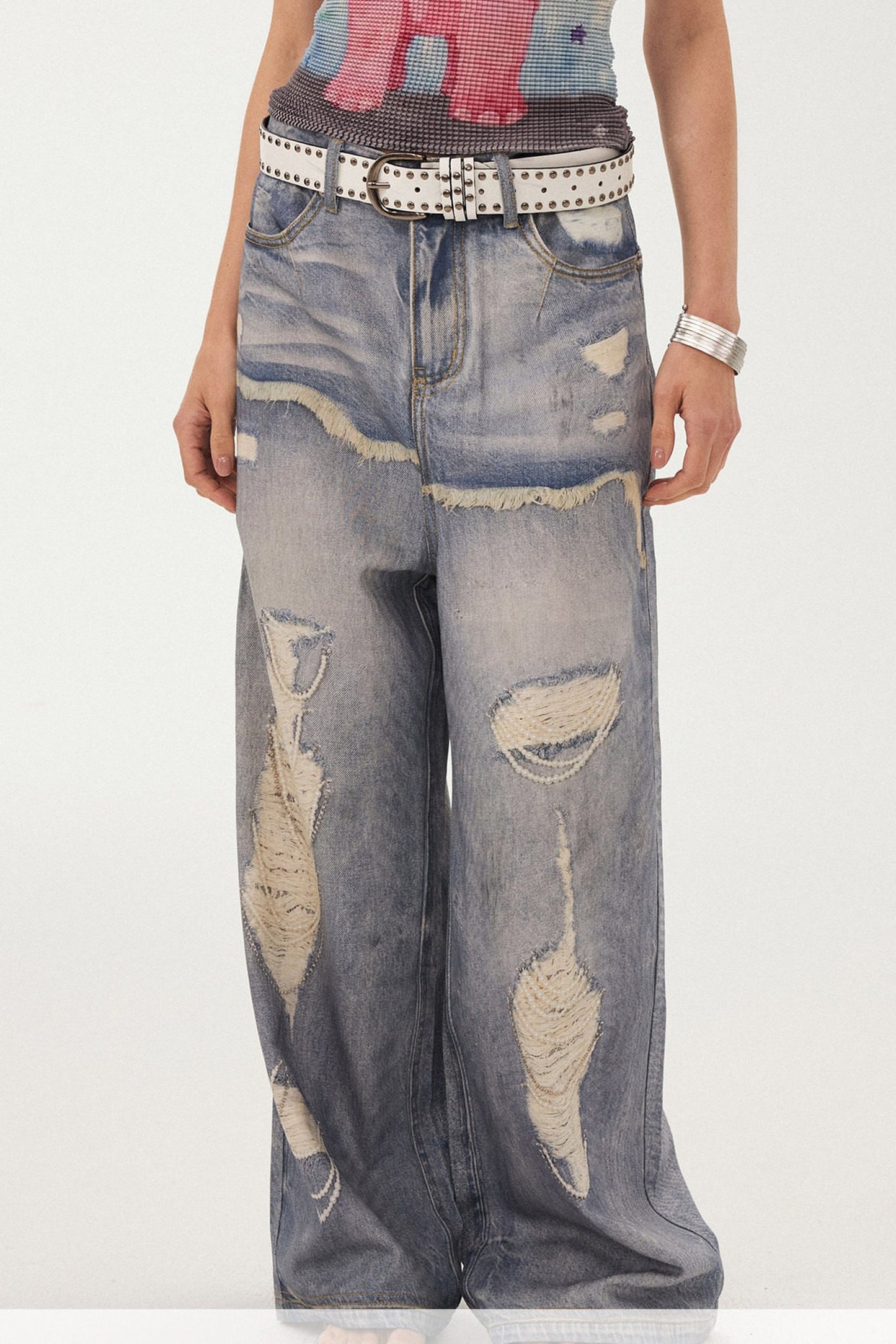 Jeans a gamba larga con stampa effetto strappato e look a strati