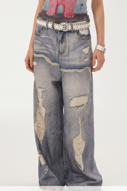 Jeans a gamba larga con stampa effetto strappato e look a strati