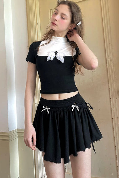 T-shirt bianca e nera a inserti con piuma e croce