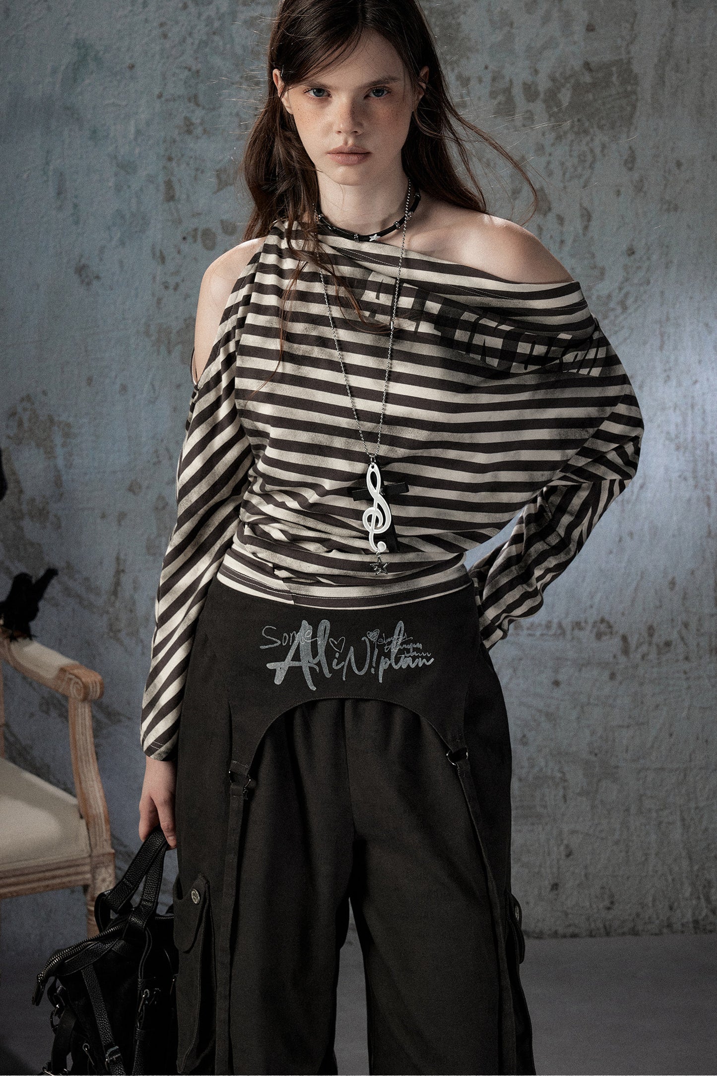 Top asimmetrico a righe con spalle scoperte e maniche lunghe