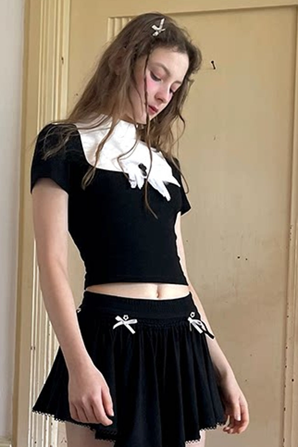 T-shirt bianca e nera a inserti con piuma e croce
