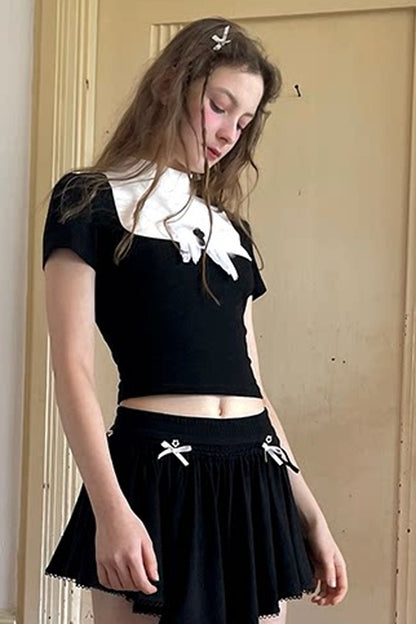 T-shirt bianca e nera a inserti con piuma e croce