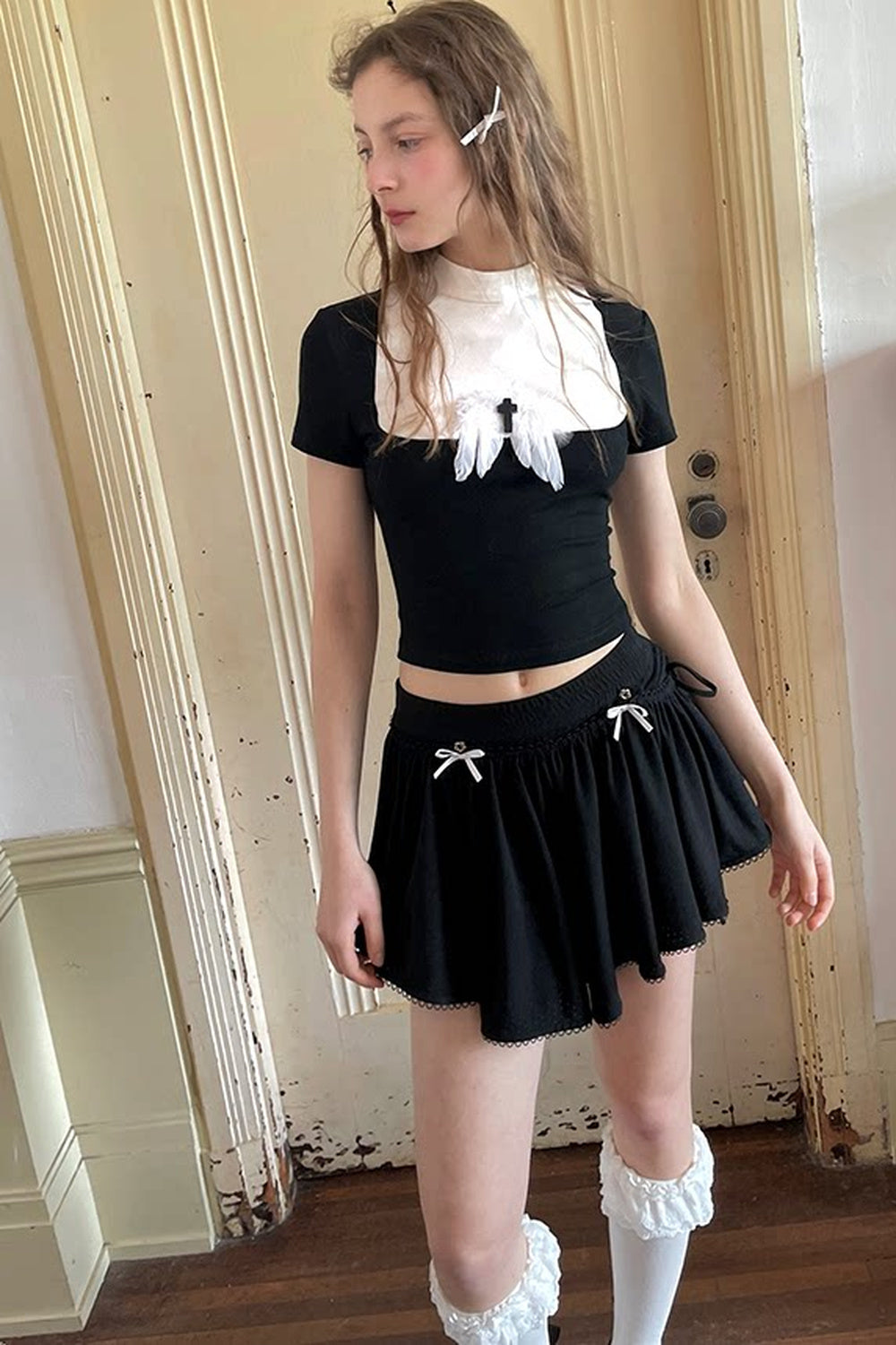 T-shirt bianca e nera a inserti con piuma e croce