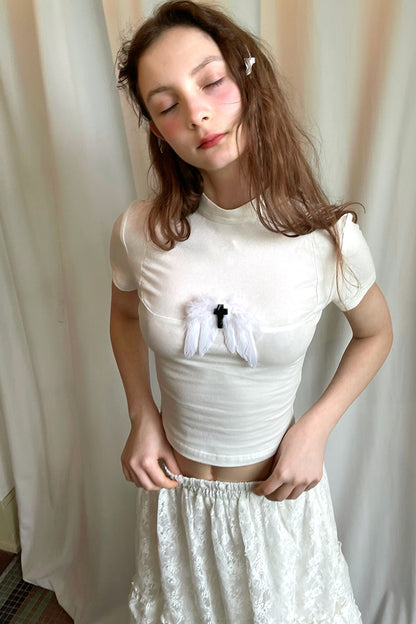 T-shirt bianca e nera a inserti con piuma e croce